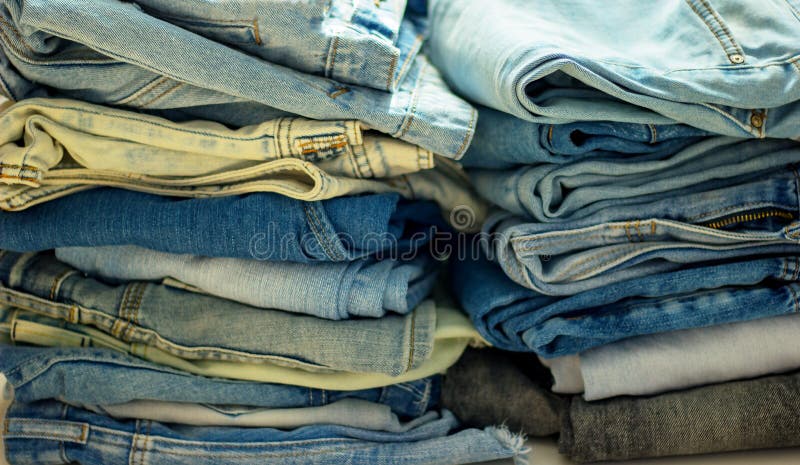 Bunt av vikt jeans av olika färger fotografering för bildbyråer Bunt av vikt jeans av olika färger fotografering för bildbyråer