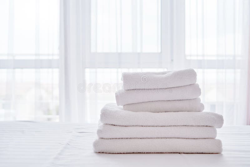 Bunt av vita rena badlakan på sängarket i den moderna hotellsovruminre, kopieringsutrymme fotografering för bildbyråer Bunt av vita rena badlakan på sängarket i den moderna hotellsovruminre, kopieringsutrymme fotografering för bildbyråer