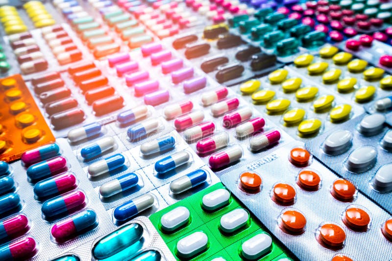 Bunt von den Tabletten und von der Kapselpille in der Sichtpackung vereinbarte mit schönem Muster viele Flaschen Medizin