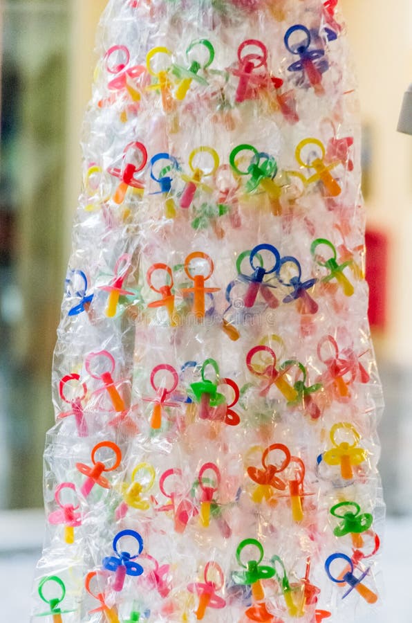 Bunte Babyfriedensstifter, die an einer Anzeige hängen lizenzfreie stockbilder