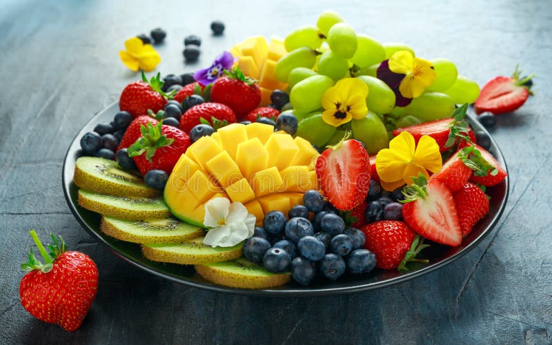 Bunte Mischfruchtservierplatte mit Mango, Erdbeere, Blaubeere, Kiwi und grüner Traube Gesunde Nahrung lizenzfreies stockbild