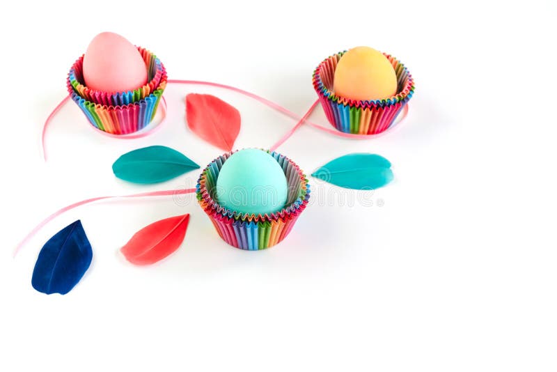 Bunte Ostereier im raibow färbten Papierformen für kleine Kuchen auf weißem Hintergrund stockfotografie Bunte Ostereier im raibow färbten Papierformen für kleine Kuchen auf weißem Hintergrund stockfotografie