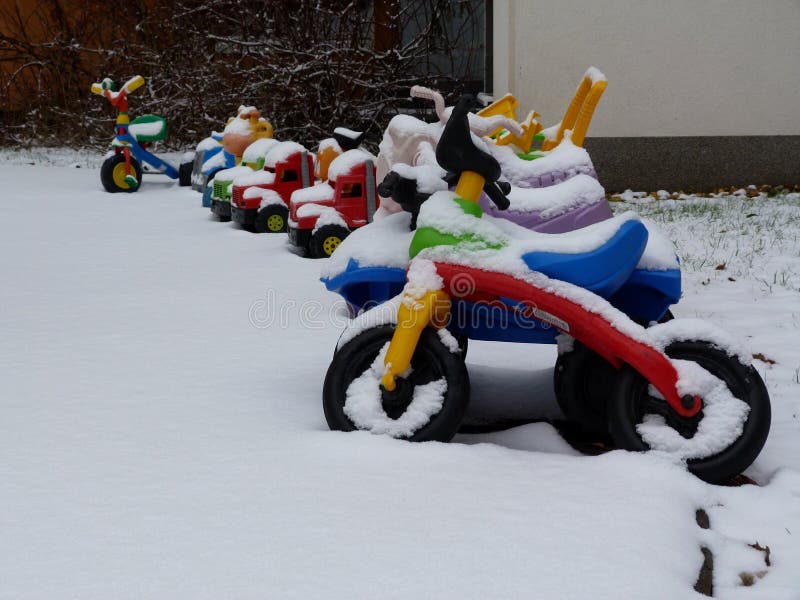 Bunte Plastikkinderspielwaren im Spielplatz mit Schneedecke stockbild Bunte Plastikkinderspielwaren im Spielplatz mit Schneedecke stockbild