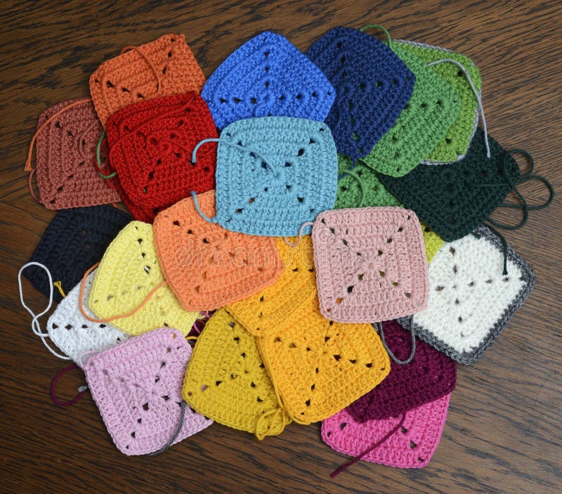 Bunte Strickquadrate auf dem Holzboden stockbild