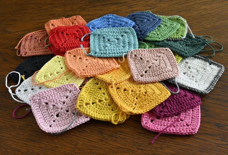 Bunte Strickquadrate auf dem Holzboden lizenzfreie stockfotos