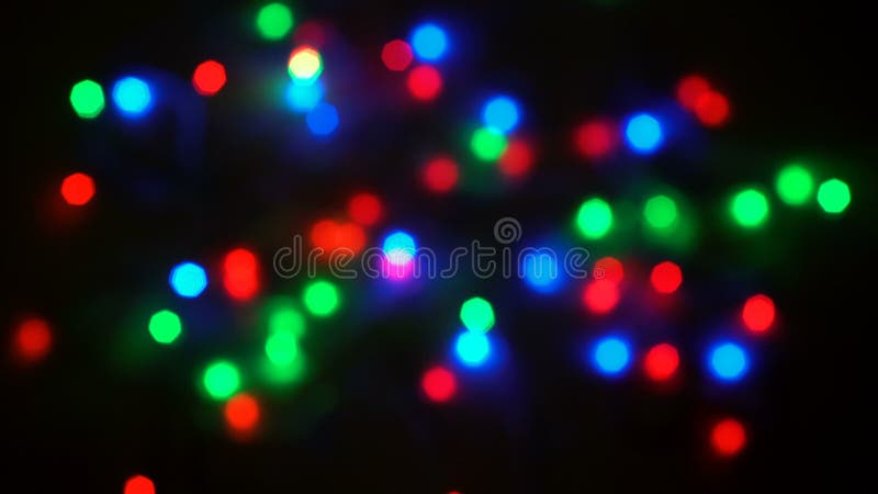 Bunte unscharfe Lichter des Girlandenblitzes in einem anderen Rhythmus auf einem schwarzen Hintergrund. Weihnachtsbeleuchtung stock footage