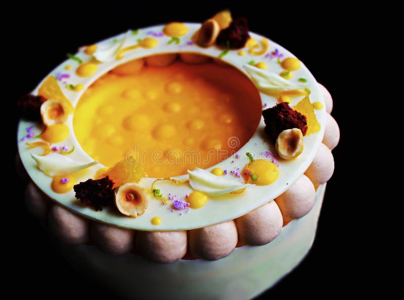 Bunter fantastischer Orangen- und Haselnusskäsekuchen lokalisiert auf schwarzem Hintergrund lizenzfreie stockbilder Bunter fantastischer Orangen- und Haselnusskäsekuchen lokalisiert auf schwarzem Hintergrund lizenzfreie stockbilder