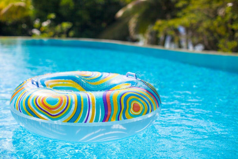 Buntes Poolfloss im blauen Schwimmenbecken stockfotos Buntes Poolfloss im blauen Schwimmenbecken stockfotos