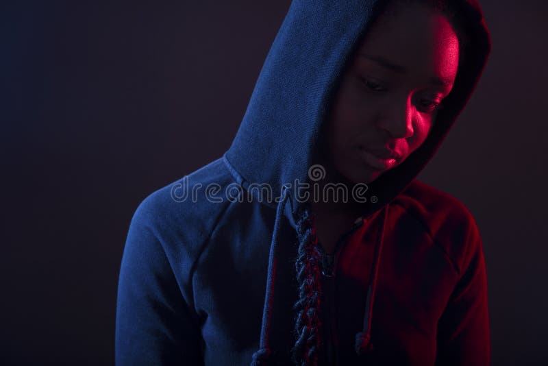 Buntes Porträt der durchdachten Frau mit dunkle Haut tragendem Hoodie lizenzfreie stockfotos Buntes Porträt der durchdachten Frau mit dunkle Haut tragendem Hoodie lizenzfreie stockfotos