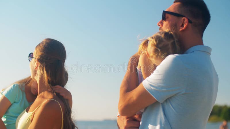 Buona famiglia con le figlie sulla spiaggia d'estate video d archivio