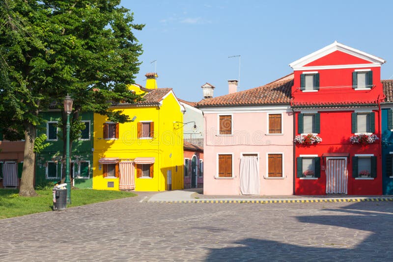 Burano, Venice, Italy colorful houses in the fishing village in. Early morning light in a deserted square. the cottages were painted in bright colors to aid the stock photography Burano, Venice, Italy colorful houses in the fishing village in. Early morning light in a deserted square. the cottages were painted in bright colors to aid the stock photography