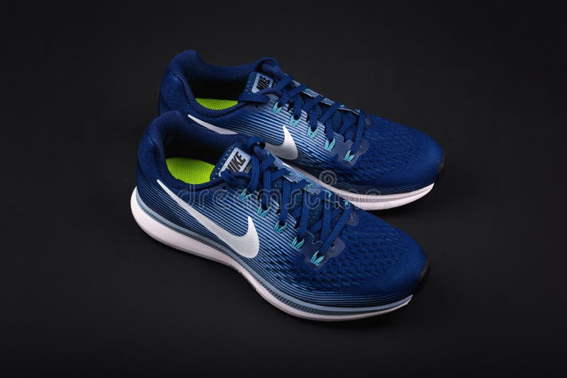 BURGAS, BULGARIJE - SEPTEMBER 6, 2017: Nike Air Zoom Pegasus 34 Vrouwen` s Loopschoenen in blauw op zwarte achtergrond royalty-vrije stock afbeelding BURGAS, BULGARIJE - SEPTEMBER 6, 2017: Nike Air Zoom Pegasus 34 Vrouwen` s Loopschoenen in blauw op zwarte achtergrond royalty-vrije stock afbeelding
