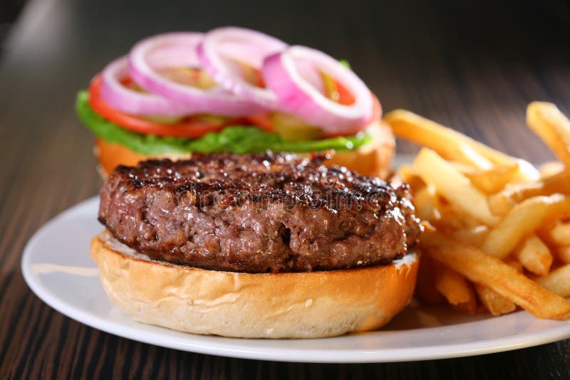 Un delizioso hamburger succoso servito con patatine fritte.