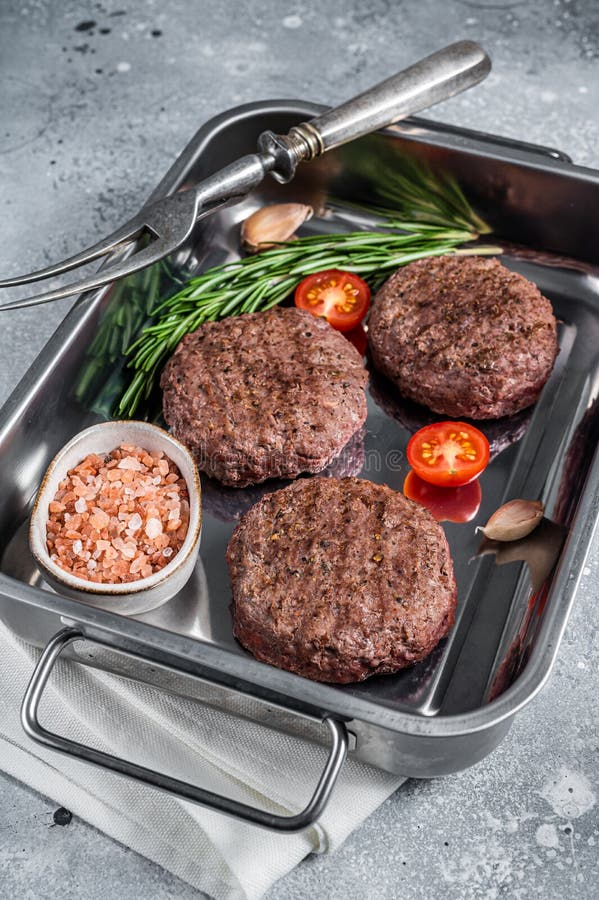 Burger Beef Meat Steak Patties with Herbs. Gray Background Stock Photo