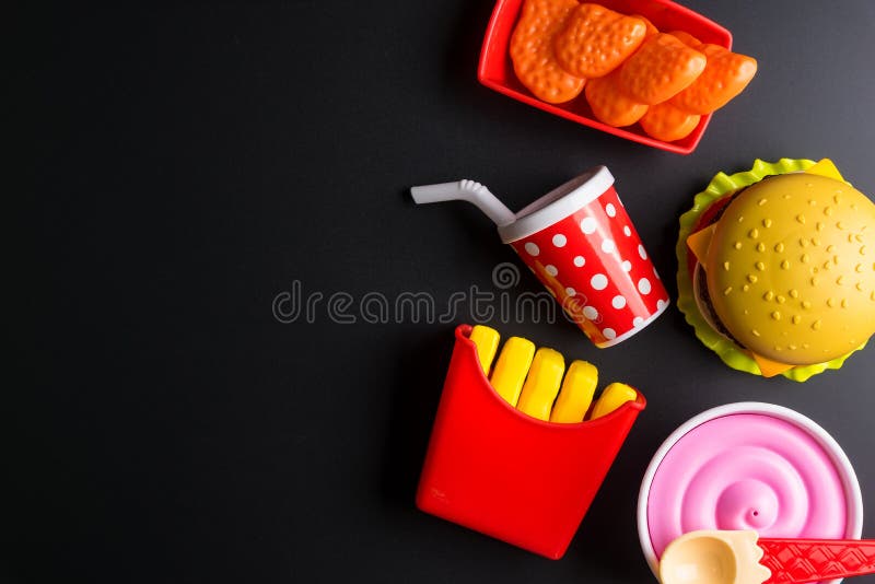 Burger di plastica, patatine fritte Cibo veloce su fondo nero giocattolo Children's Concetto di alimenti artificiali nocivi fotografia stock Burger di plastica, patatine fritte Cibo veloce su fondo nero giocattolo Children's Concetto di alimenti artificiali nocivi fotografia stock