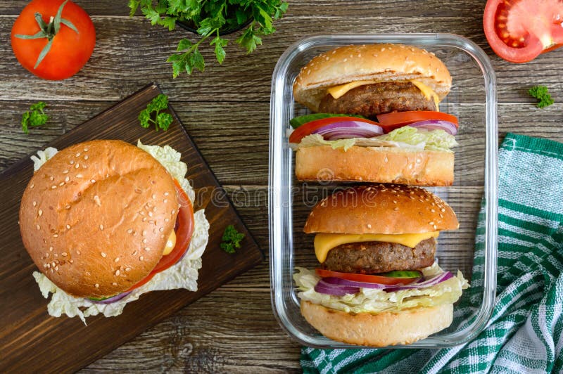 Burger mit saftigem Kotelett, Frischgemüse, knusperiges Brötchen mit Samen des indischen Sesams auf einem Holztisch Traditionelle lizenzfreie stockfotos Burger mit saftigem Kotelett, Frischgemüse, knusperiges Brötchen mit Samen des indischen Sesams auf einem Holztisch Traditionelle lizenzfreie stockfotos