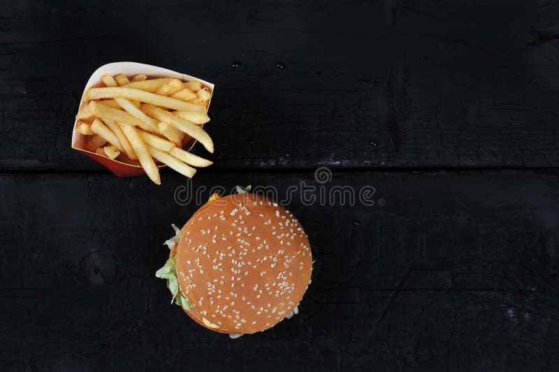 Burger με το κουλούρι και τις τηγανιτές πατάτες σουσαμιού στοκ εικόνες