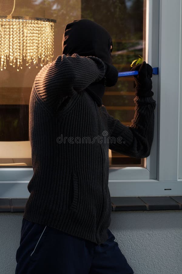 Vertical view of burglar opening the window