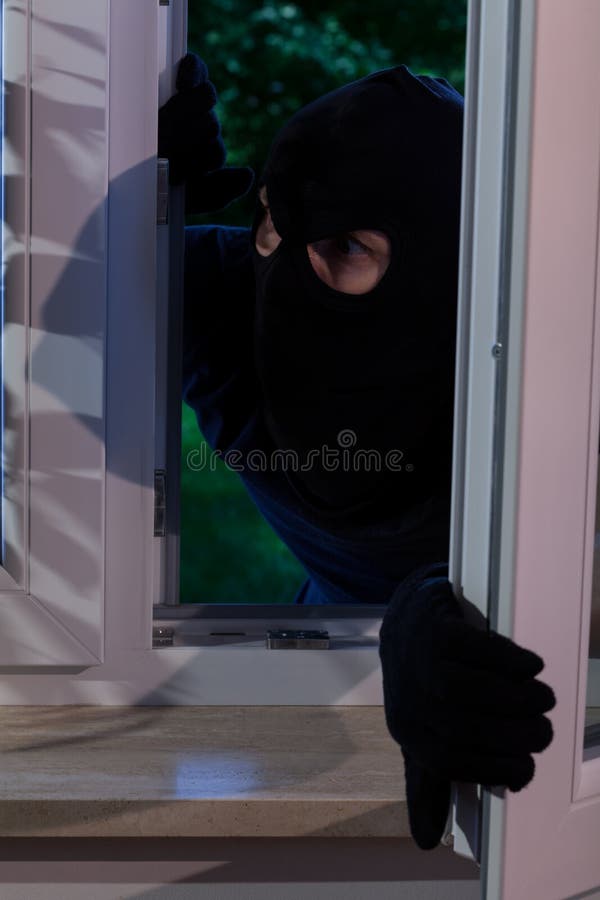 Vertical view of burglar opening the window