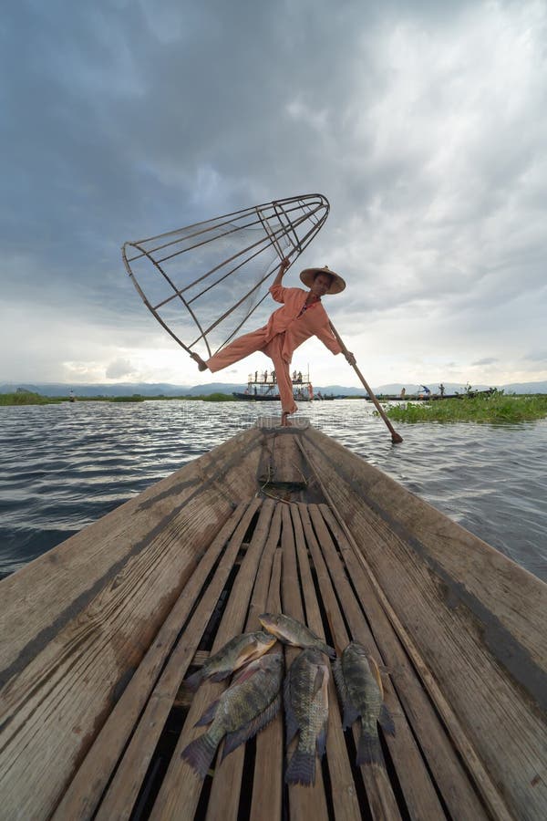 Burmische Fischer gießen oder werfen ein Netz zum Fang von Süßwasserfischen in einem natürlichen Fluss des Sees in Asia in Myanmar stockfotos