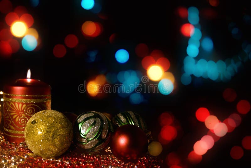 Burning candle with Christmas-tree decorations