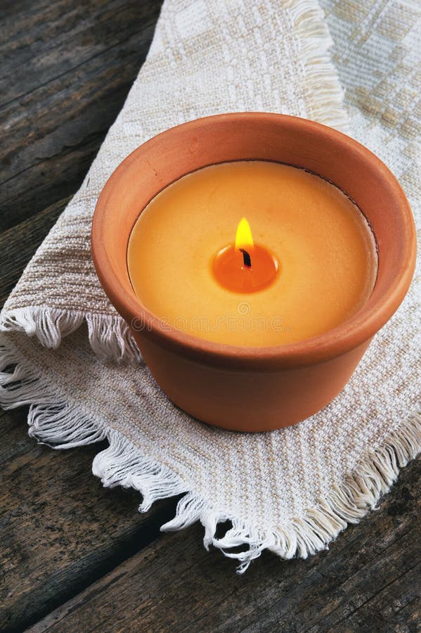 Burning Candle in a Clay Pot on a Wooden Background Stock Photo Image