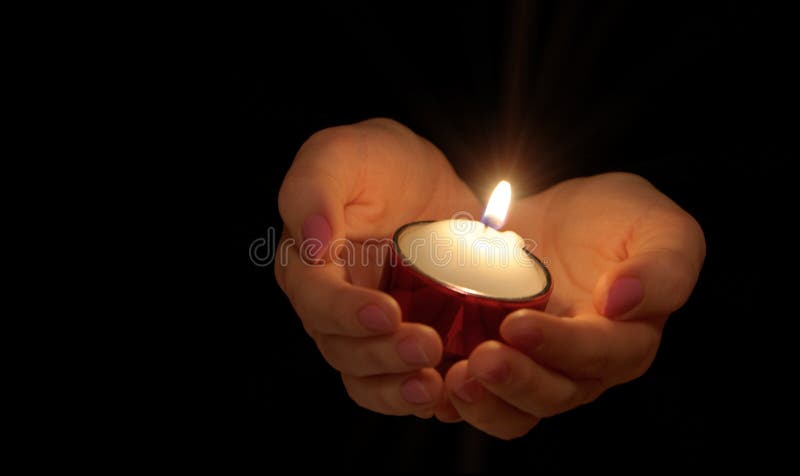 Burning candle in female hands