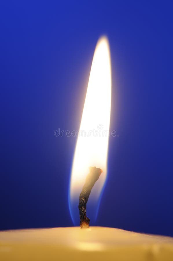 Burning Candle Flame Close-Up on Blue Background