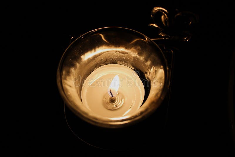 Burning Candle in a Glass Candlestick in the Dark. Decoration Candle