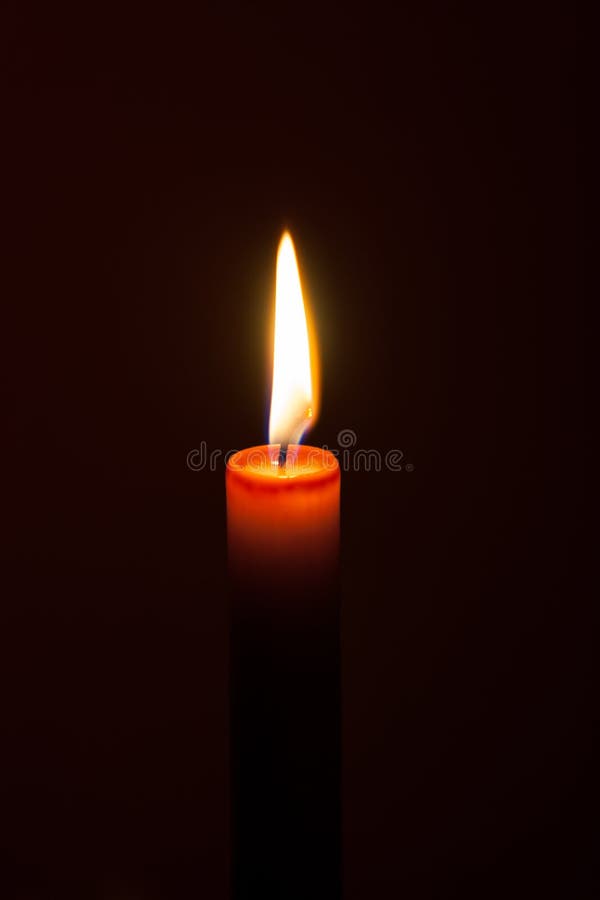 A burning candle at night. Symbol of life, love and light, protection and warmth. Candle flame glowing on a dark background. stock image A burning candle at night. Symbol of life, love and light, protection and warmth. Candle flame glowing on a dark background. stock image