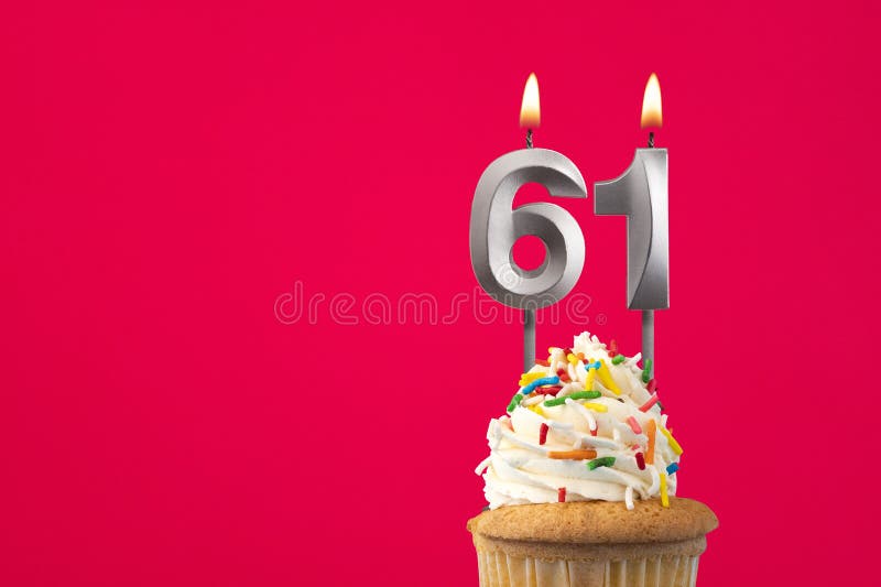 Burning candle number 61 - Birthday card with cake stock photography