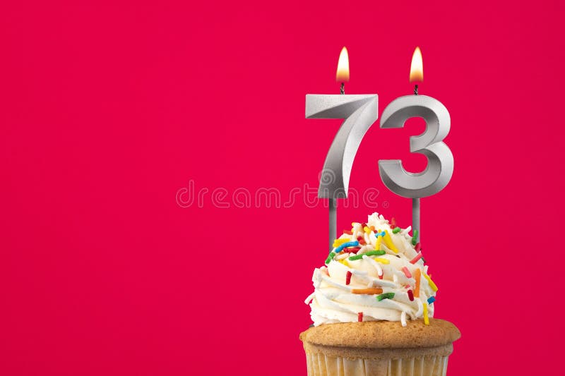 Burning candle number 73 - Birthday card with cake stock images