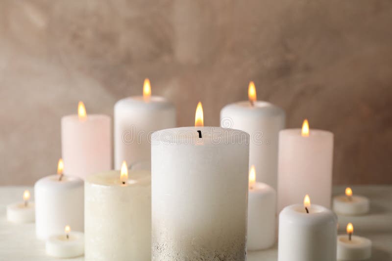 Burning candles against brown background stock photo
