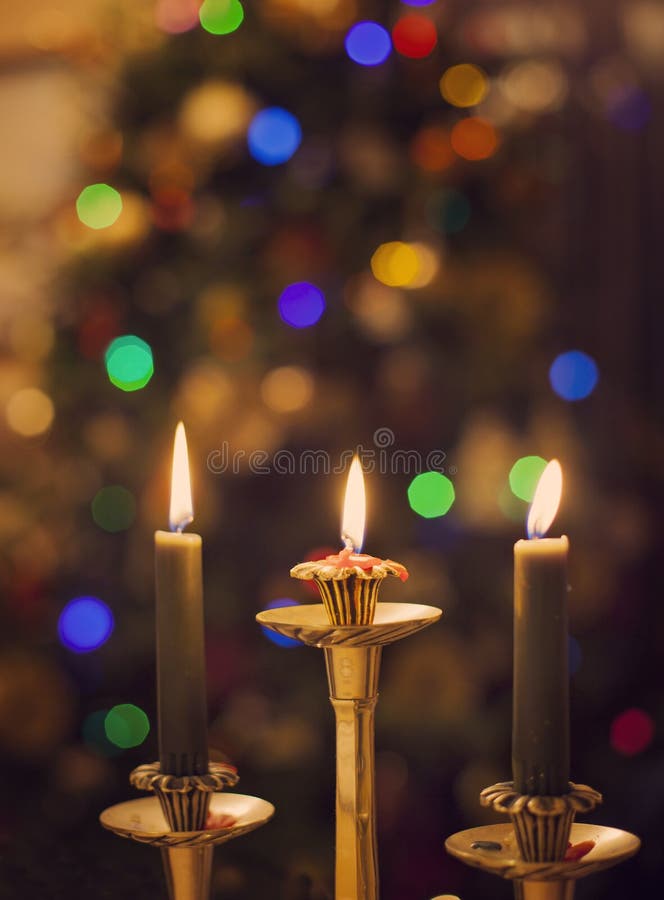Burning Candles on Blurring Christmas Lights Background Stock Photo