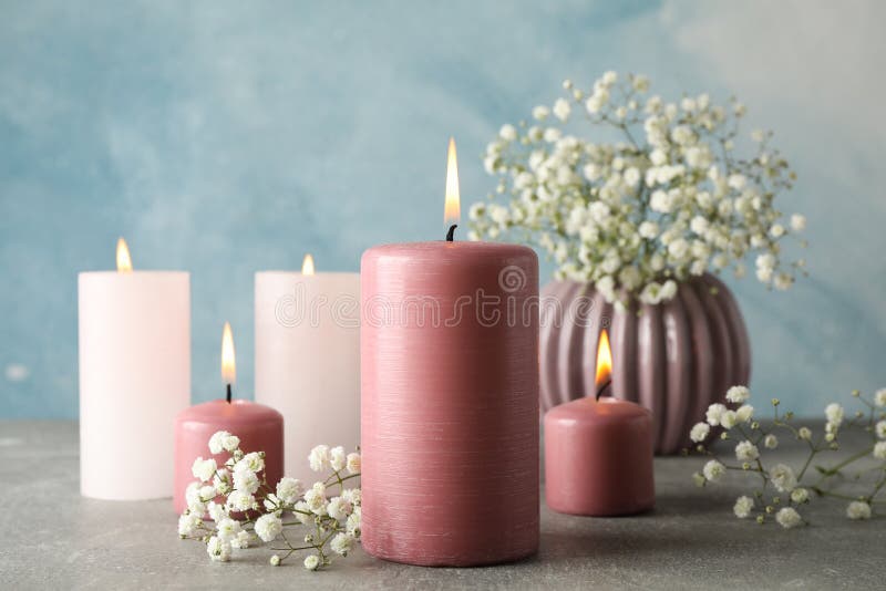 Burning candles and flower against background, space for text