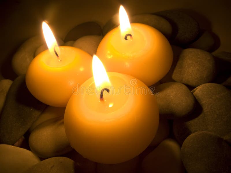 Burning Candles on Sea Stones stock photo