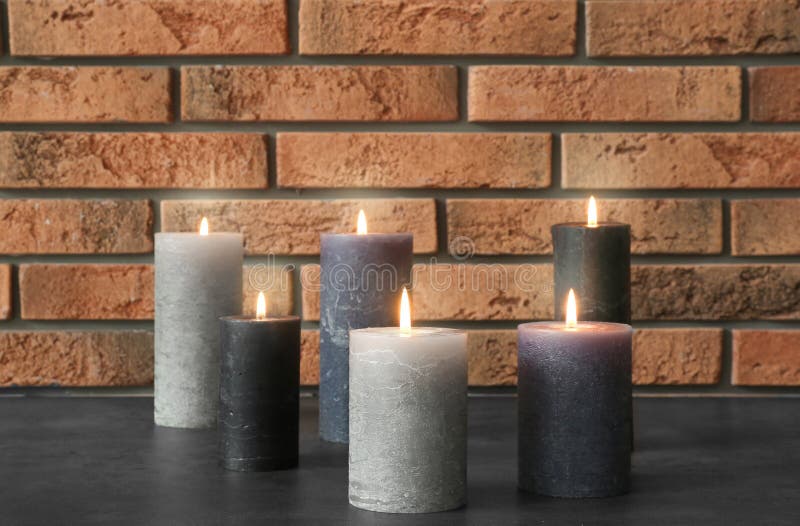 Glass Holder with Burning Wax Candle Near Roses on Wooden Table Stock