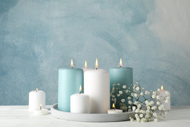 Burning candles, tray and flower against background, space for text stock photo