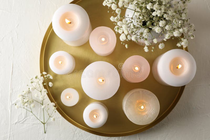 Burning candles, tray and flower on white table royalty free stock photography