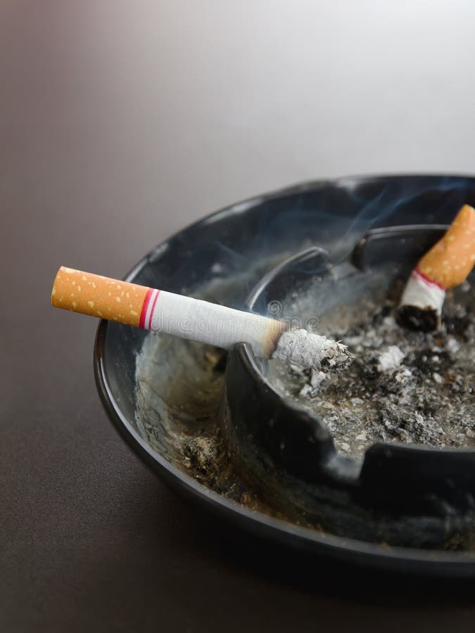 Burning Cigarette in Ashtray and Smoke on the Table Stock Image Image