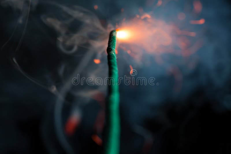 Burning fuse. Dynamite firecracker green fuse burn with sparkles and smoke  on black background. Stock Photo