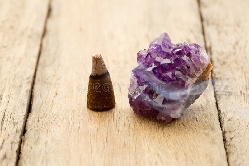 Burning incense cone with amethyst crystal with wafting smoke on royalty free stock image Burning incense cone with amethyst crystal with wafting smoke on royalty free stock image
