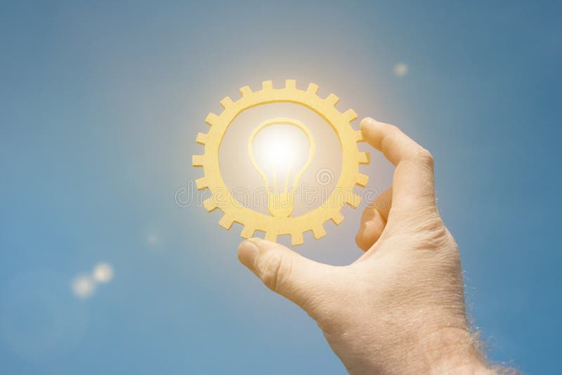 A burning lamp is an idea in the businessman`s hand, against the sky. stock photo A burning lamp is an idea in the businessman`s hand, against the sky. stock photo