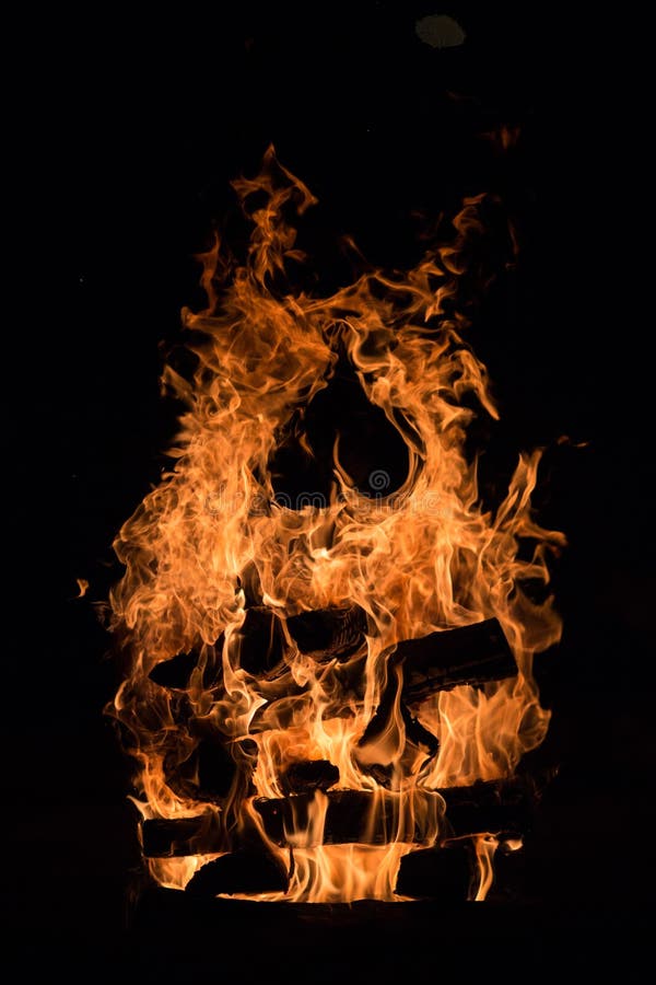 Burning logs and fire with a heart inside stock photography