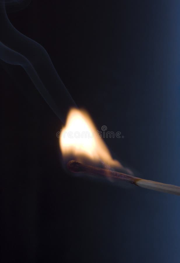 Macro burning match with black background.