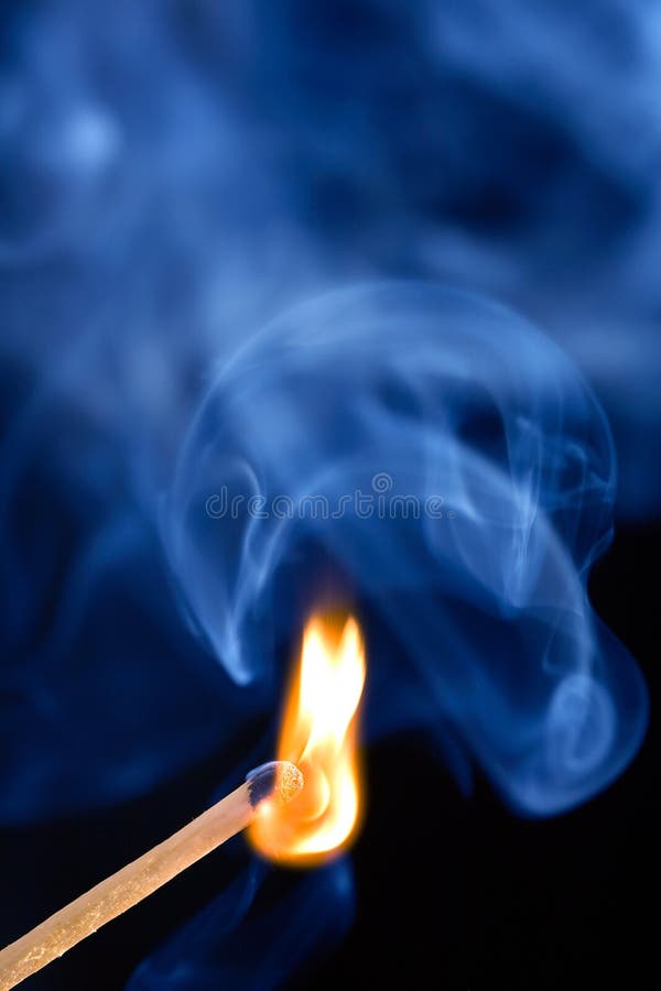 Macro shot of burning match and smoke background.