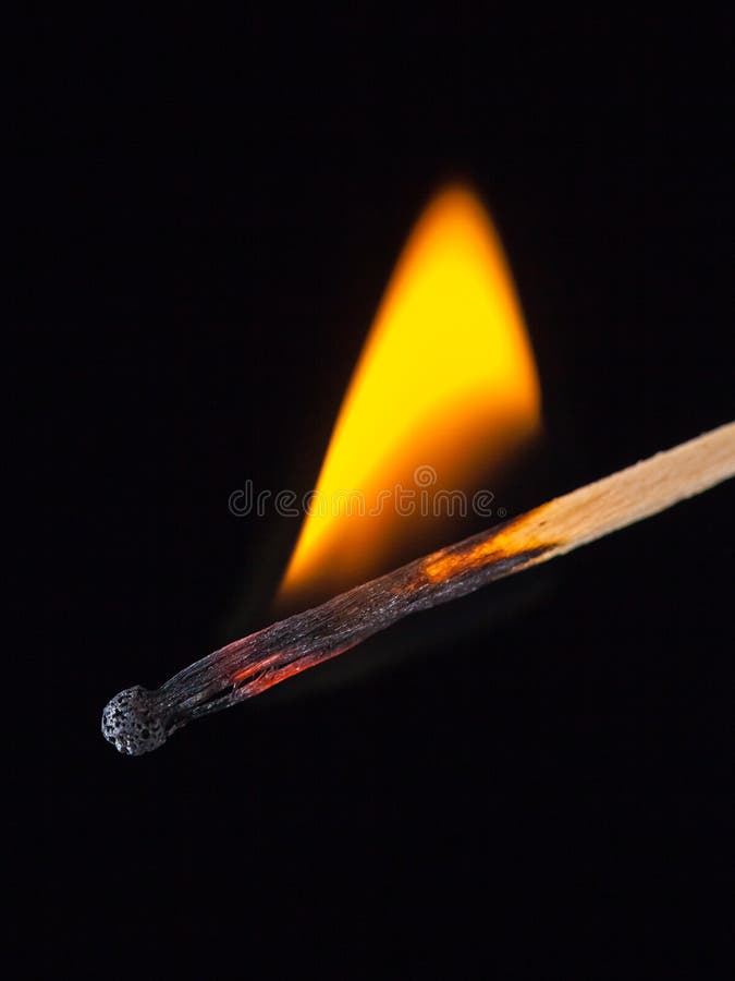 Burning match stick in the hand on a black isolated background