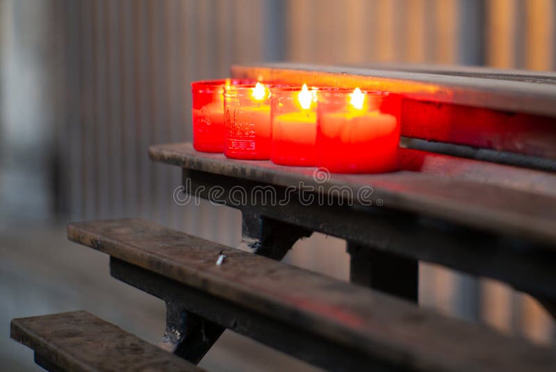 Burning red candles in a church in Barcelona