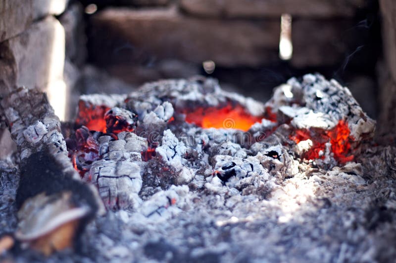 Burning red hot coals on the background of brick