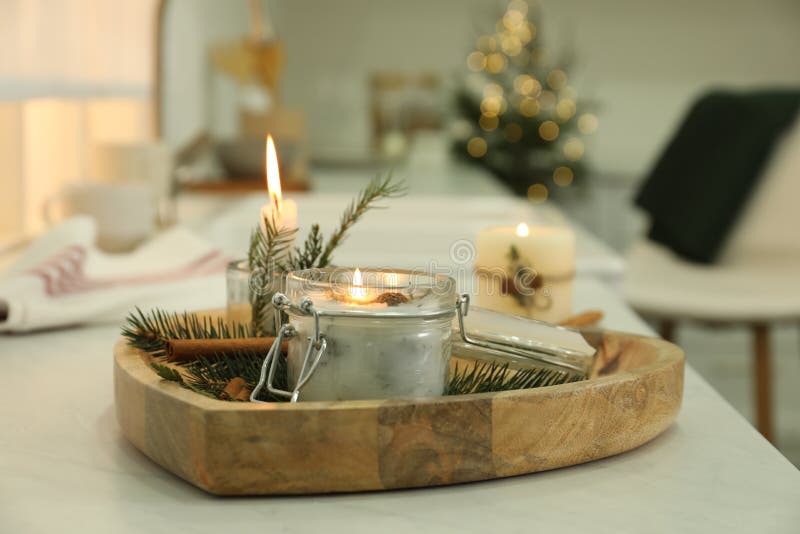 Burning Scented Conifer Candle on White Table Indoors Stock Photo